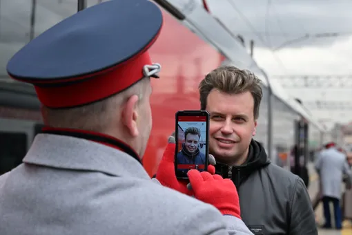 Проводник поезда проверяет биометрические данные пассажира